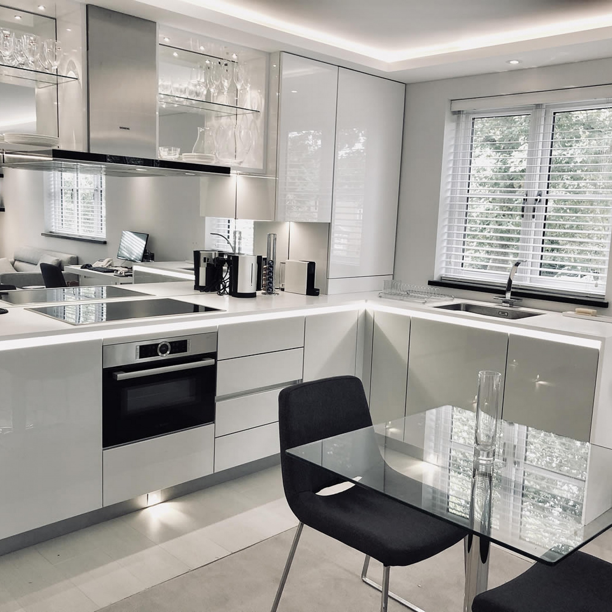 Designer White Kitchen for London pied-a-terre apartment, units are Hacker-Systemat high gloss grey lacquer with the upper units in high gloss white