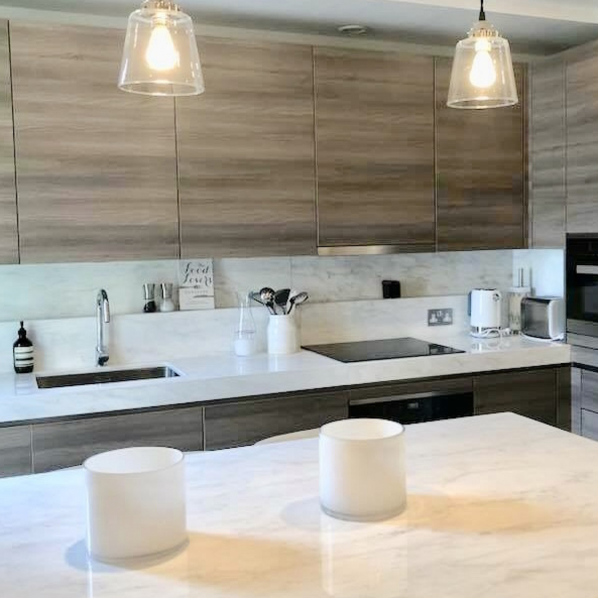 Exclusive designer kitchen marble surfaces South Kensington, with Miele appliances handle-less design in a horizontal veneer cabinets